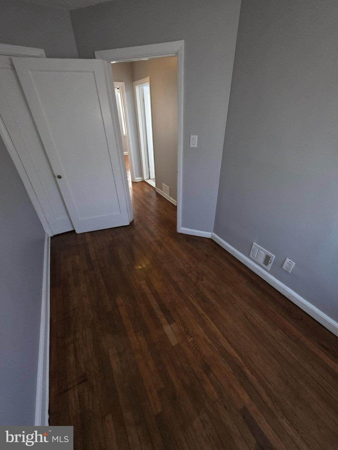4404 Mountview Road Baltimore, MD 21229 - Photo 18 of 22 a view of an empty room with wooden floor and a window