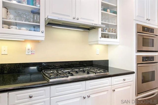 a kitchen with stainless steel appliances granite countertop a stove and a microwave