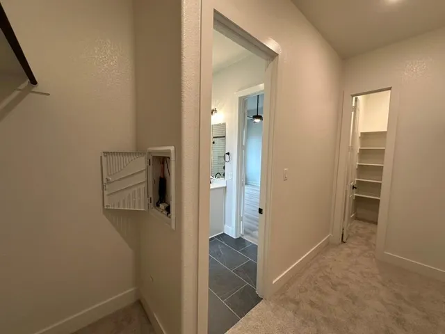 an entryway and a hallway with a room