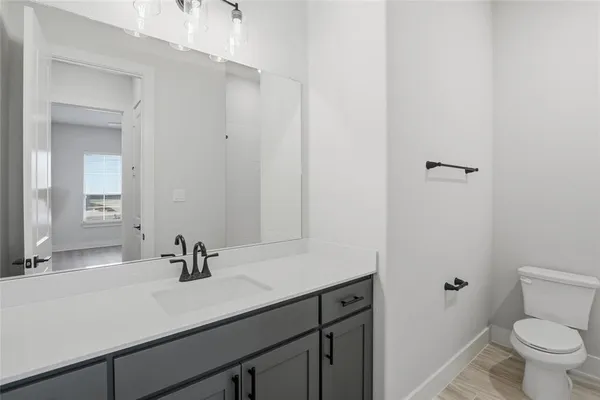 a bathroom with a sink a toilet and a mirror