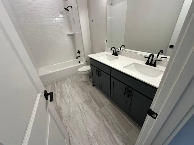 a bathroom with a sink a toilet a mirror and shower