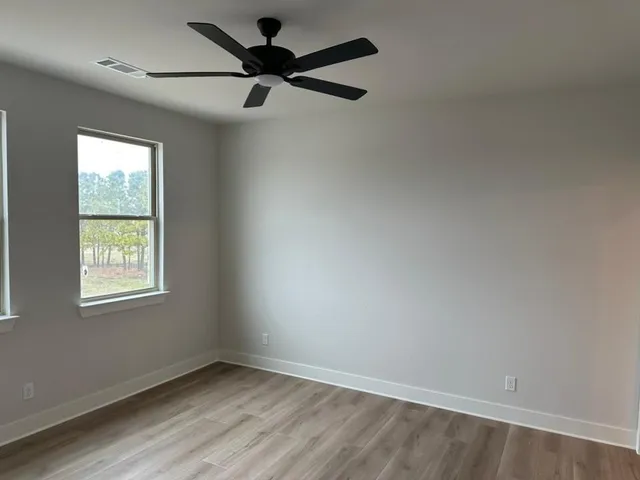 an empty room with a window and a fan