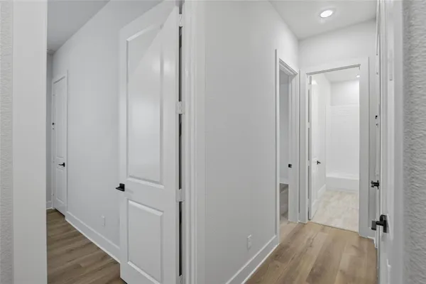a view of a hallway with wooden floor
