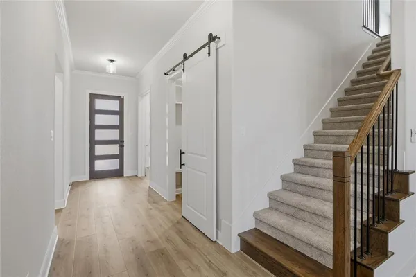 a view of a hallway with wooden floor and entryway
