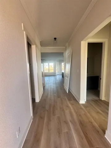 a view of a hallway with wooden floor and glass door