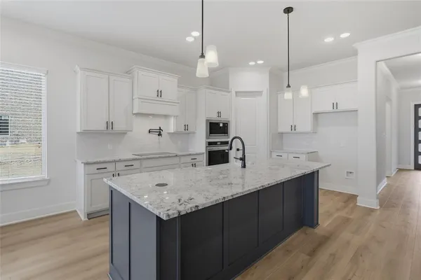 a kitchen with a center island wooden floor stainless steel appliances and windows