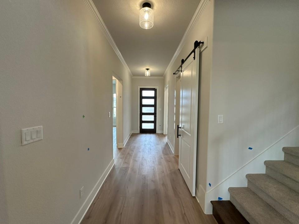 330 Cobb Road Leonard, TX 75452 - Photo 5 of 26 Doorway with a barn door, ornamental molding, wood finished floors, and stairway