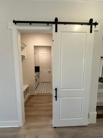 a view of a hallway with wooden floor and staircase