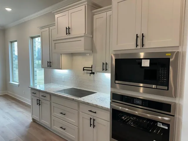 a kitchen with granite countertop a stove and cabinets