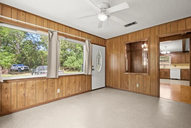 a view of an empty room with a kitchen and a window
