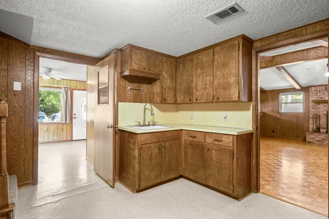 a kitchen with stainless steel appliances granite countertop a sink and a stove next to a window