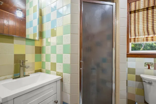 a bathroom with a sink a toilet and shower