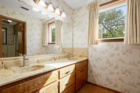 a bathroom with a granite countertop sink mirror and a shower