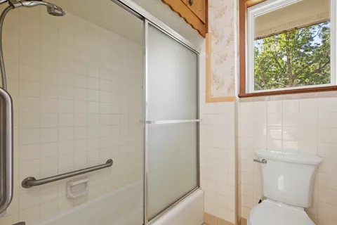 a bathroom with a toilet and a shower