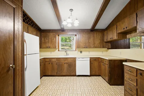 a kitchen with stainless steel appliances granite countertop a sink a stove and refrigerator