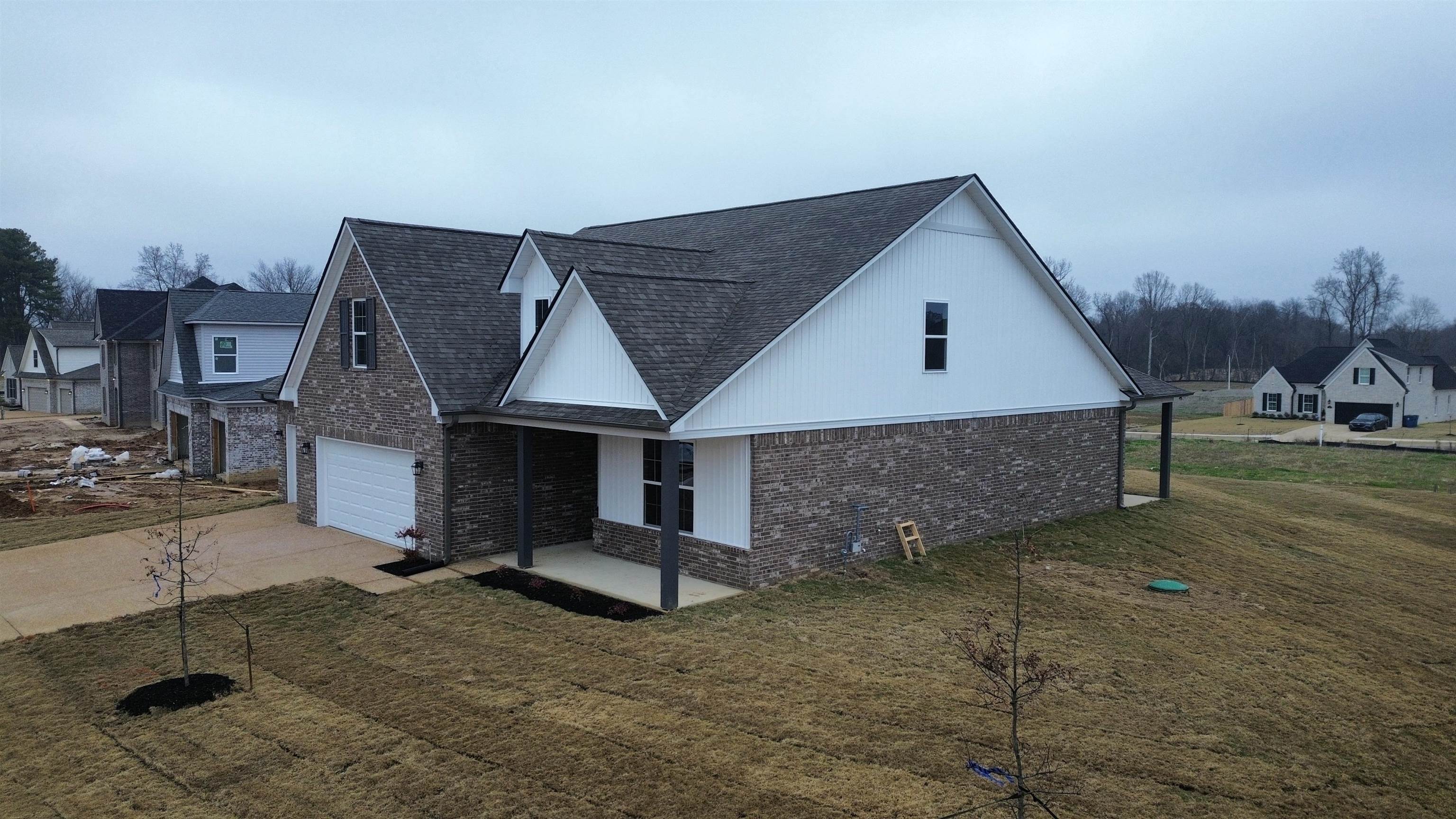170 Como Lane Atoka, TN 38004 - Photo 24 of 27 View of home's exterior featuring brick siding, a yard, concrete driveway, and covered porch