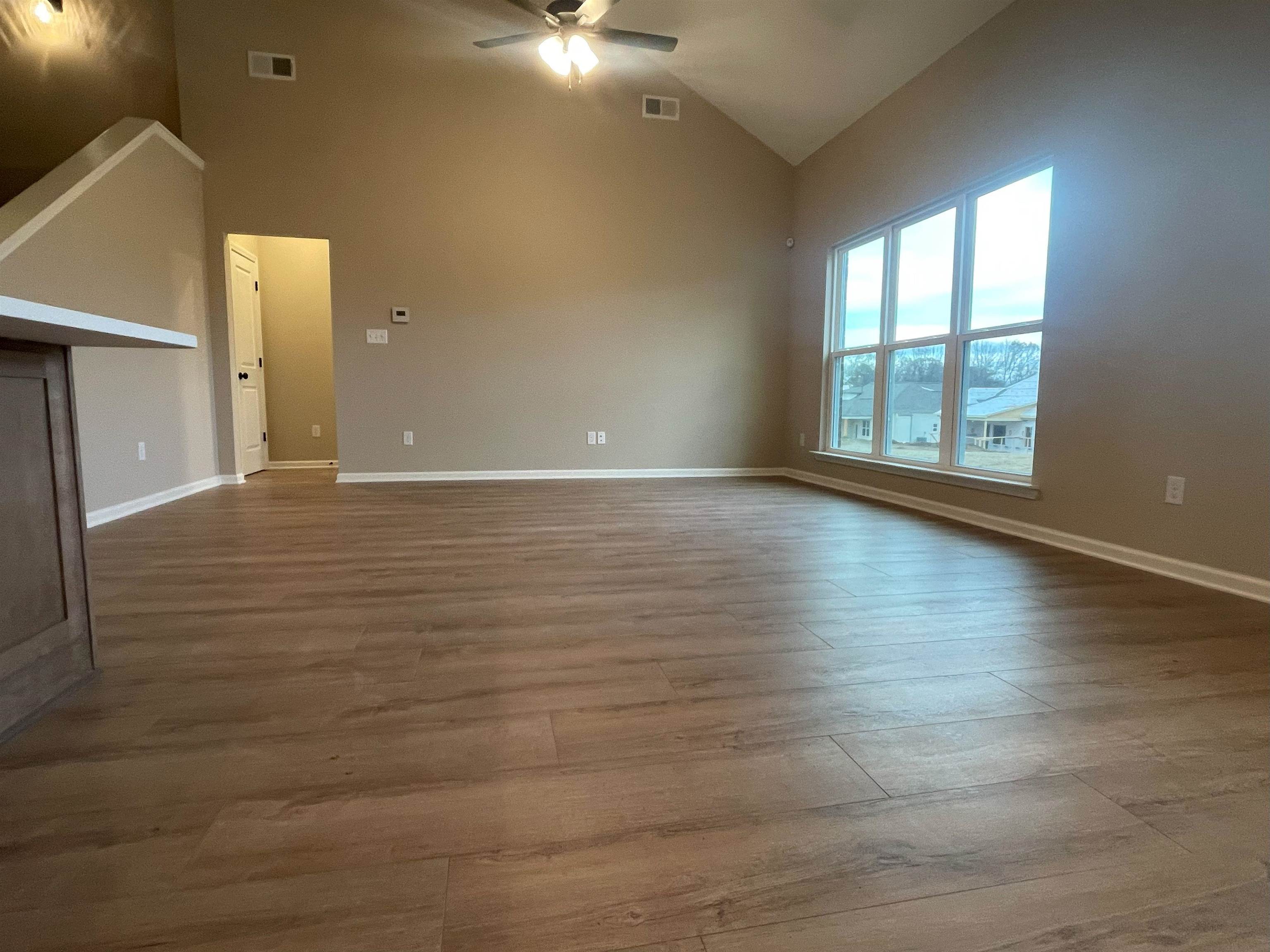 170 Como Lane Atoka, TN 38004 - Photo 3 of 27 a view of an empty room with wooden floor and a window