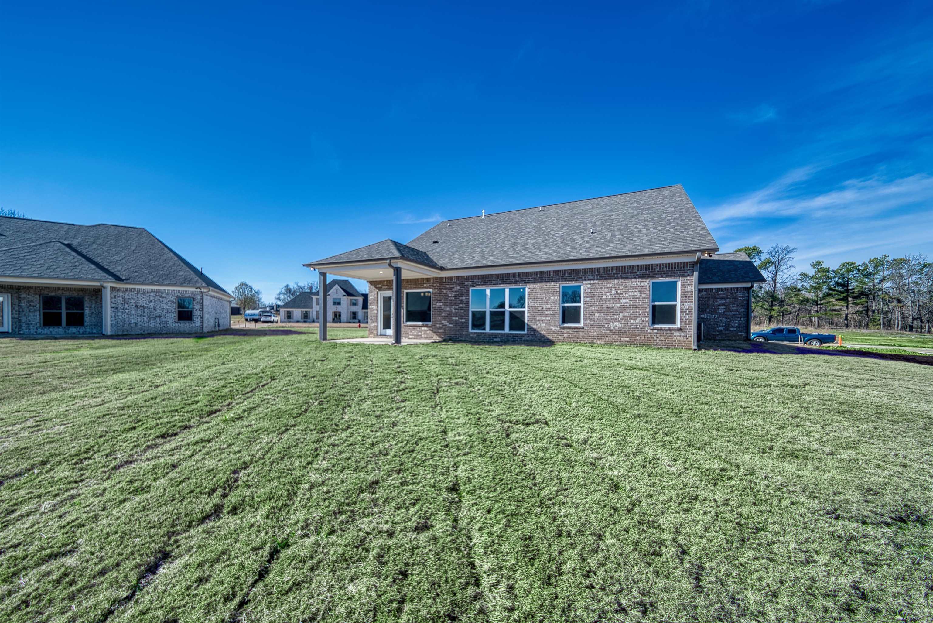 170 Como Lane Atoka, TN 38004 - Photo 38 of 40 Rear view of house featuring a patio, a yard, a shingled roof, and brick siding