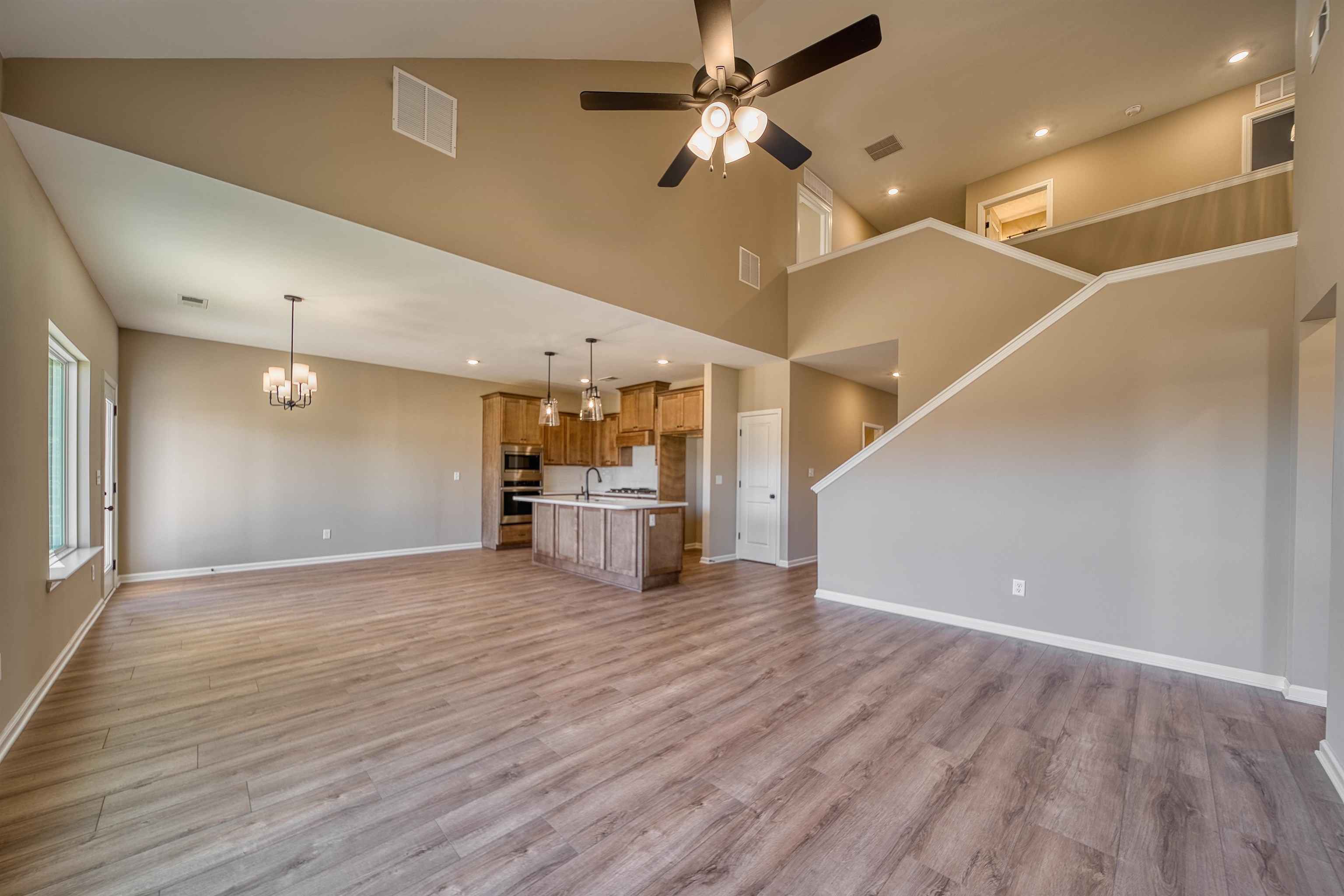 170 Como Lane Atoka, TN 38004 - Photo 5 of 40 Unfurnished living room featuring ceiling fan, hanging lights, light wood-style flooring, and a high ceiling