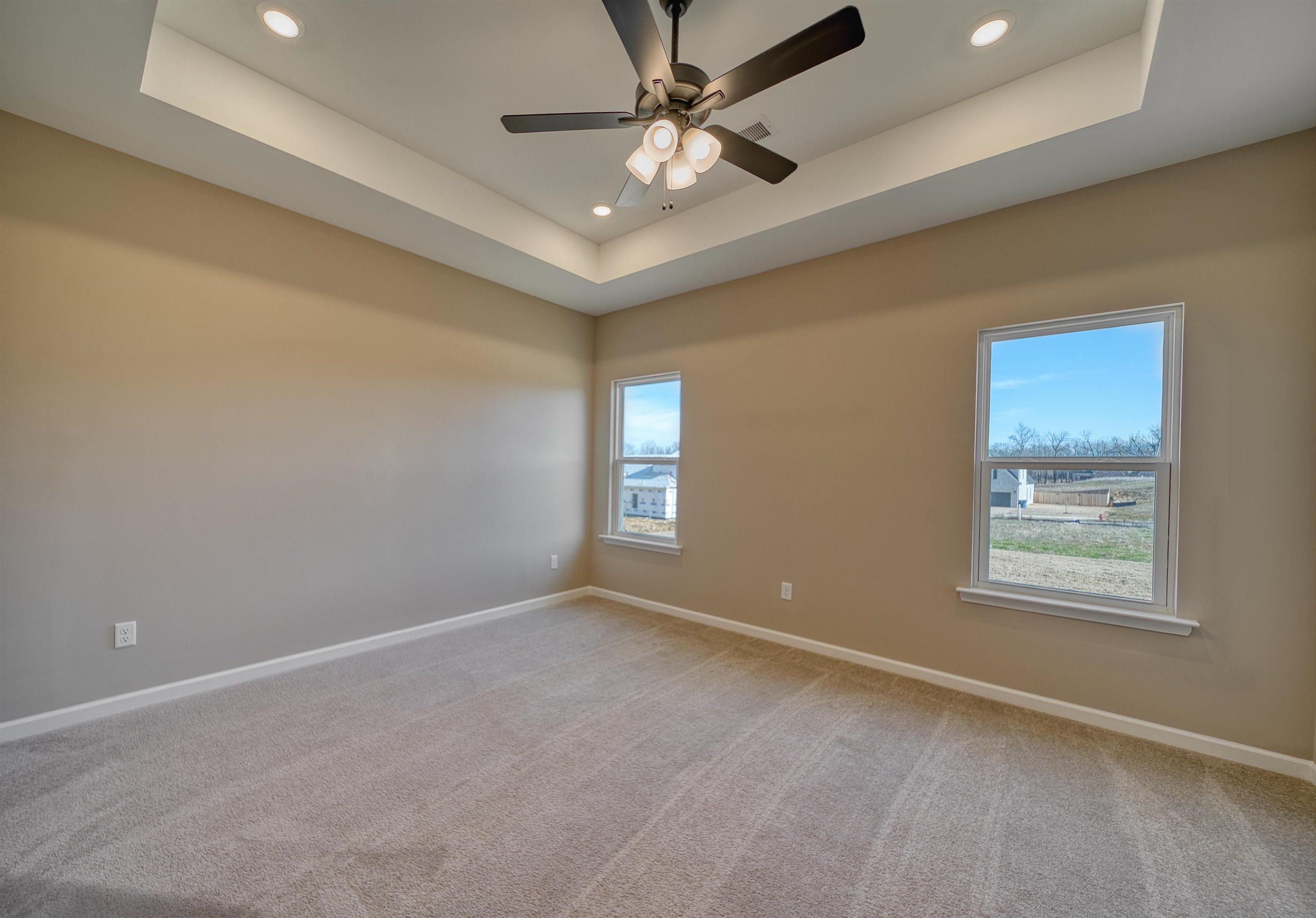 170 Como Lane Atoka, TN 38004 - Photo 6 of 40 Empty room featuring recessed lighting, ceiling fan, light colored carpet, and a tray ceiling