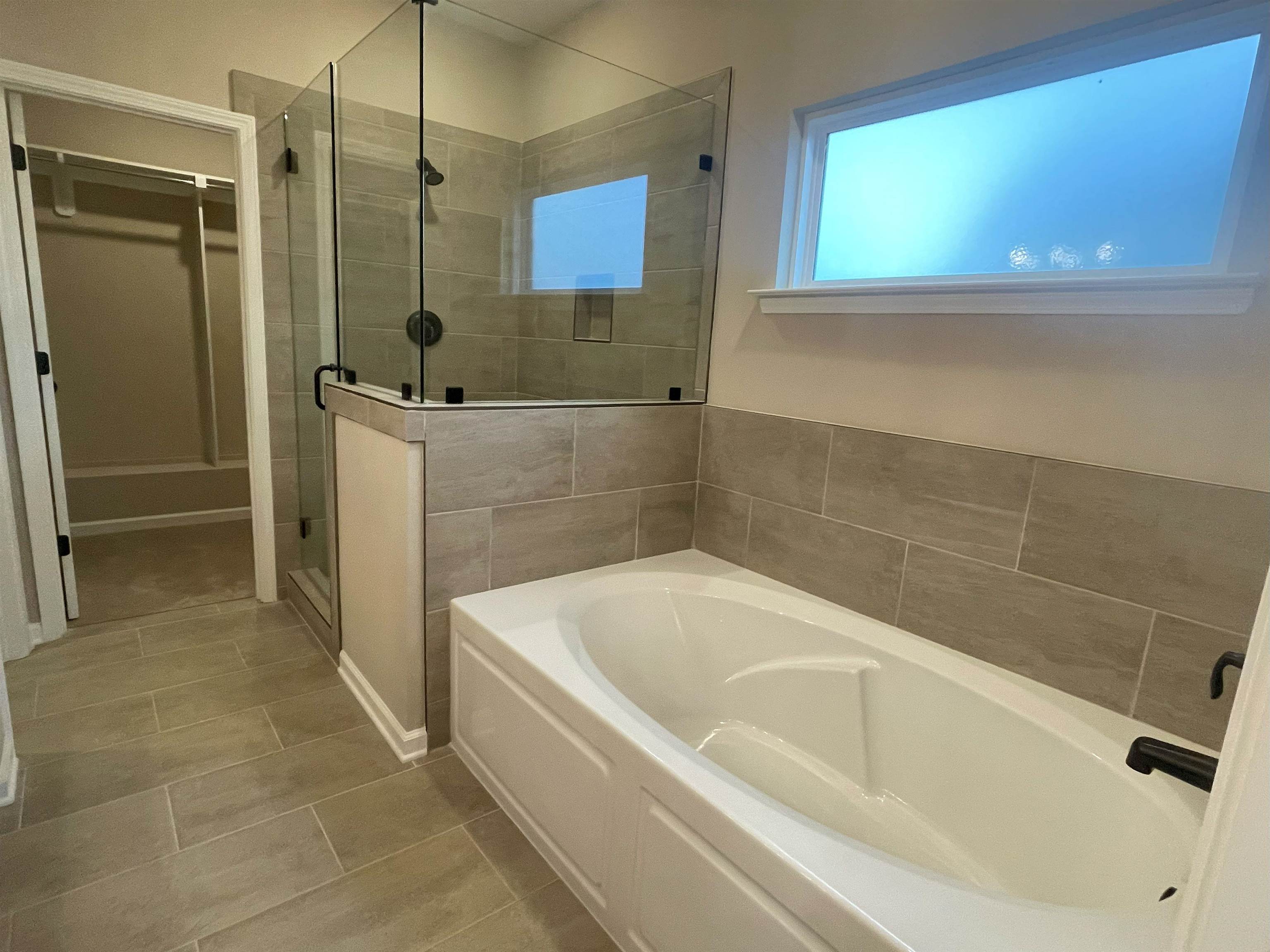 170 Como Lane Atoka, TN 38004 - Photo 7 of 27 Bathroom with a garden tub, a spacious closet, a stall shower, and light tile patterned floors