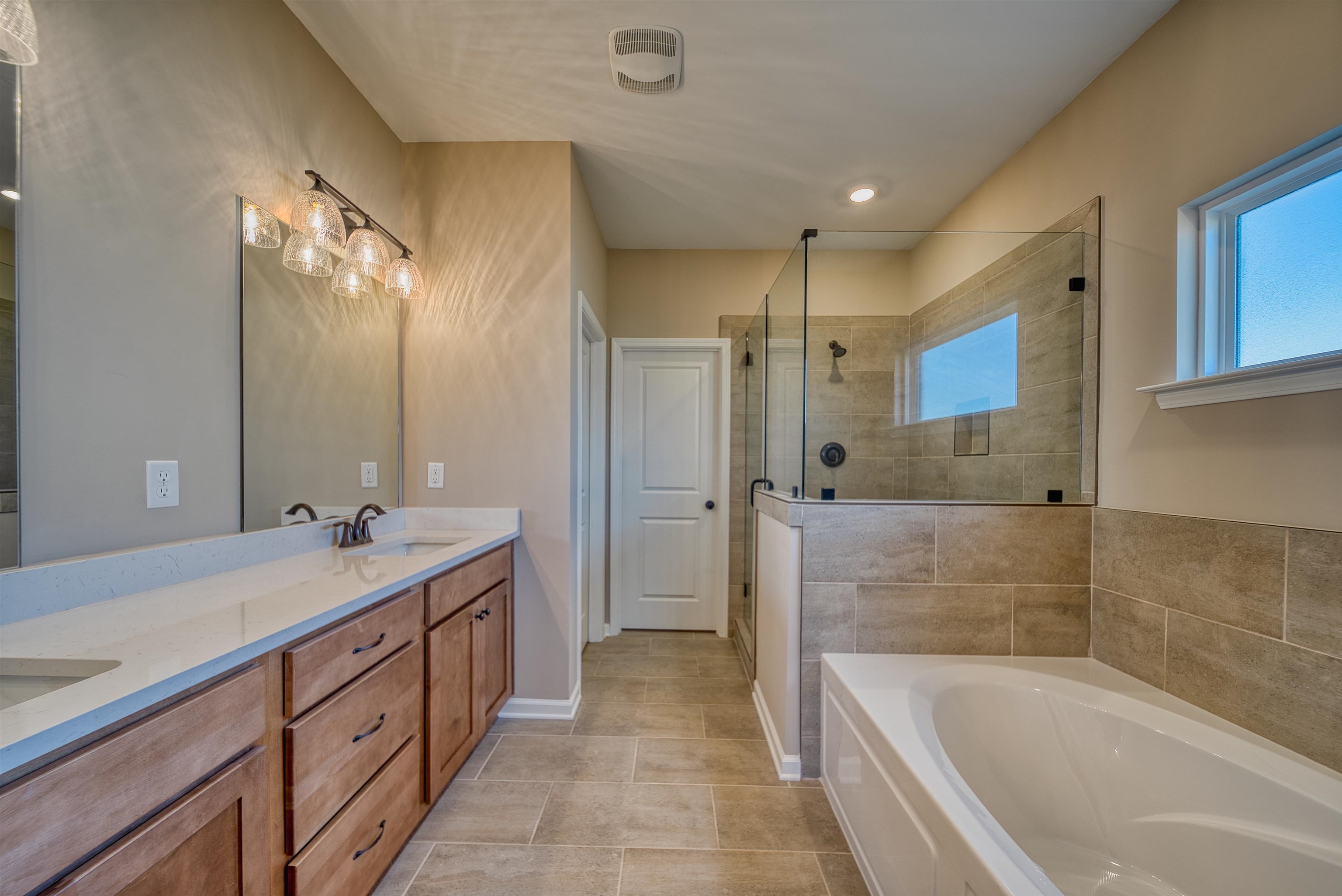 170 Como Lane Atoka, TN 38004 - Photo 7 of 40 Full bathroom featuring a bath, double vanity, a tile shower, and light tile patterned floors