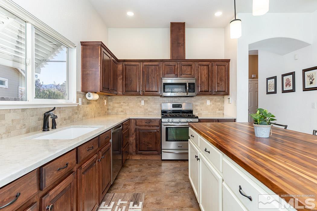 9778 Thunder Mountain Way Reno, NV 89521 - Photo 9 of 21 a kitchen with kitchen island granite countertop a sink stainless steel appliances and counter space