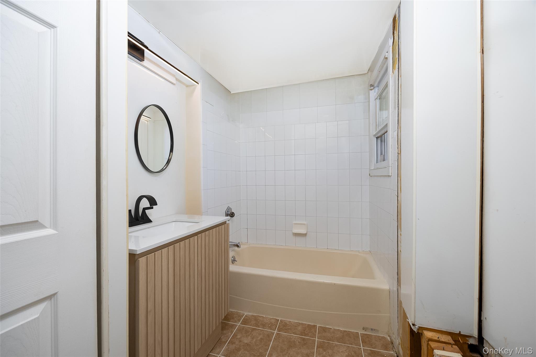 29 Delano Street, Unit 2 Poughkeepsie, NY 12601 - Photo 5 of 16 a bathroom with a granite countertop sink a toilet and a bathtub