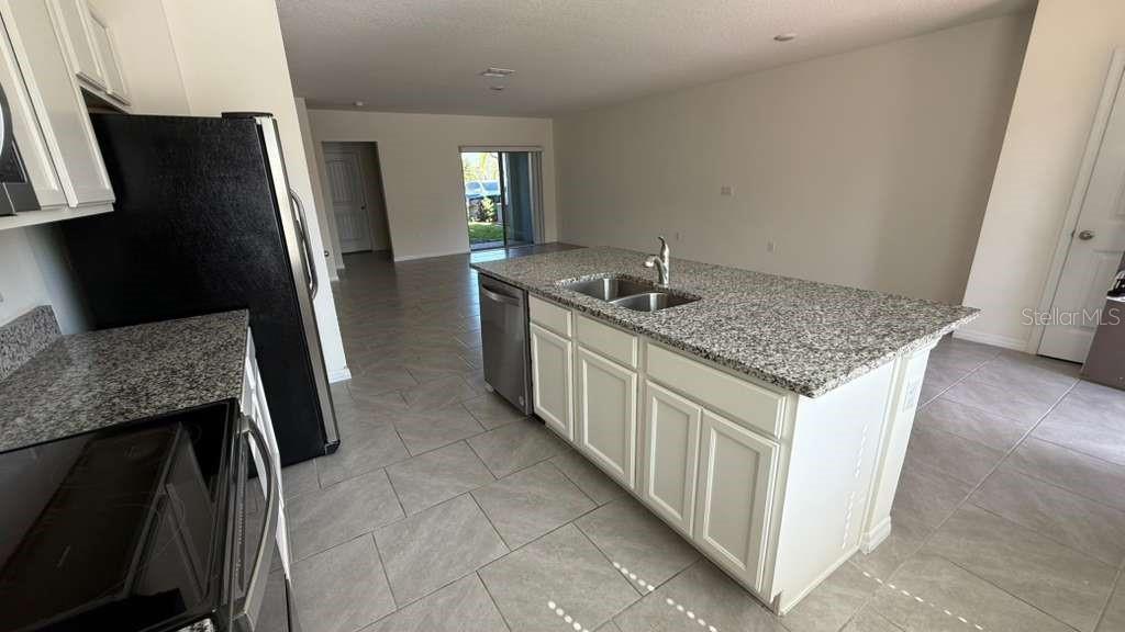 17061 Water Spring Boulevard Winter Garden, FL 34787 - Photo 5 of 17 a kitchen with stainless steel appliances granite countertop a sink stove and refrigerator