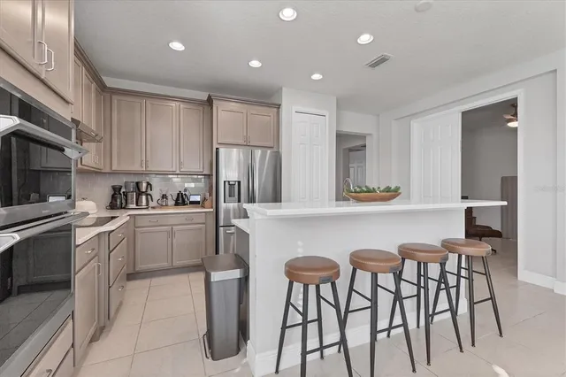 a kitchen with a refrigerator sink and cabinets