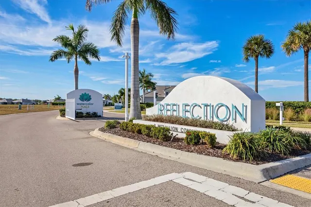 a front view of a house with a yard and potted plants