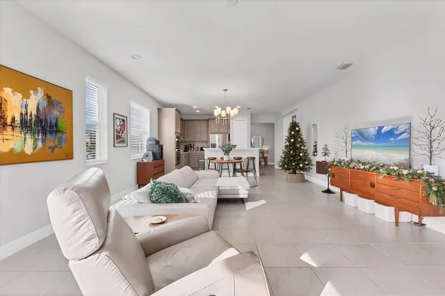 a living room with furniture and a dining table with kitchen view