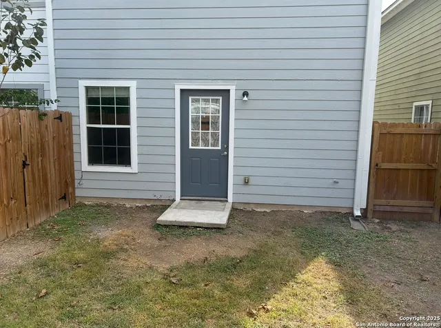 a view of a backyard with wooden fence