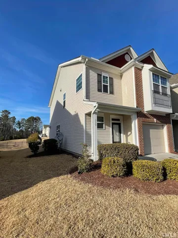 a view of a white house with a yard in front of it