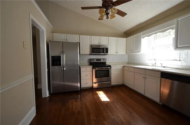 a kitchen with a sink stainless steel appliances and window