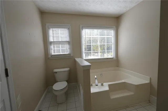 a bathroom with a granite countertop toilet a sink and a bathtub