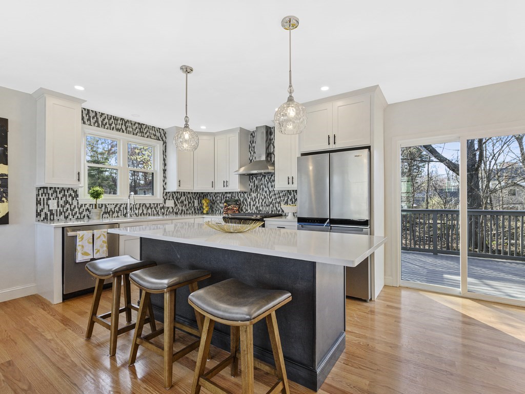 33 Line Road Reading, MA 01867 - Photo 3 of 23 a kitchen with stainless steel appliances granite countertop a sink a stove a refrigerator and island with wooden floor