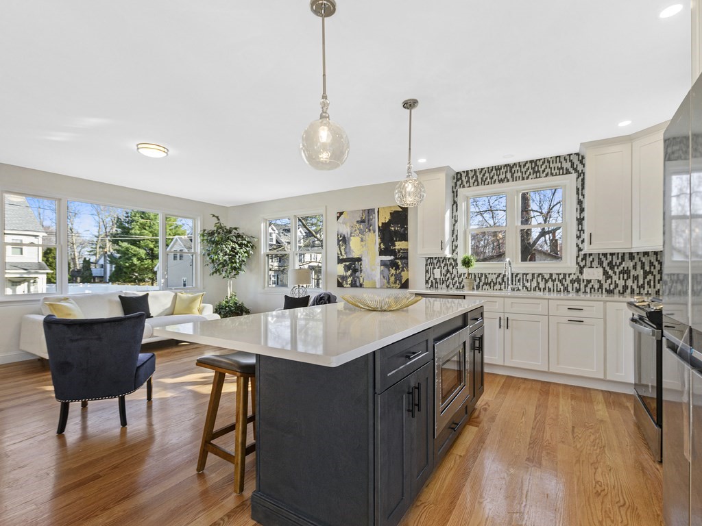 33 Line Road Reading, MA 01867 - Photo 4 of 23 a kitchen with a table chairs stove and wooden floor