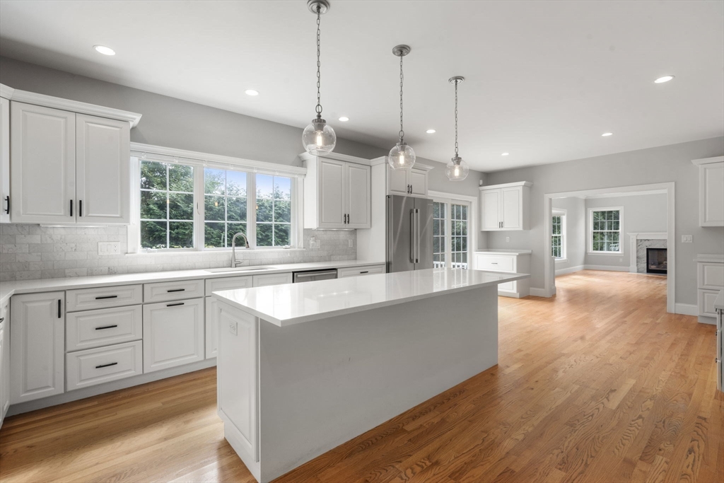 173 Benvenue Street Wellesley, MA 02482 - Photo 4 of 34 a large kitchen with kitchen island a large window a sink and stainless steel appliances