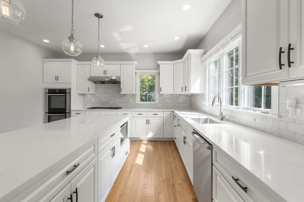 173 Benvenue Street Wellesley, MA 02482 - Photo 6 of 34 a large kitchen with kitchen island a large counter top space a sink stainless steel appliances and cabinets