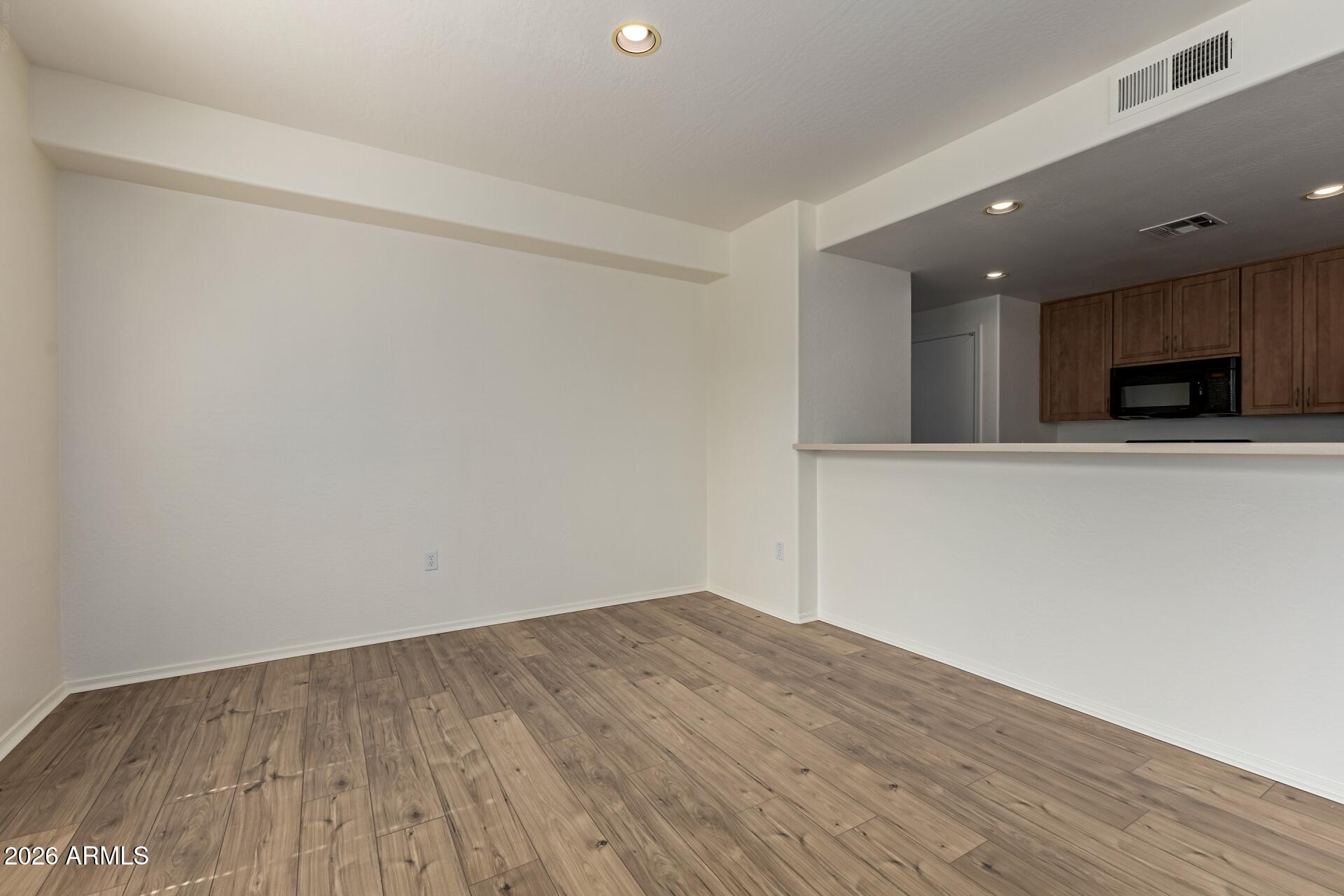 705 West Queen Creek Road, Unit 1167 Chandler, AZ 85248 - Photo 5 of 31 a view of an empty room with wooden floor and a window