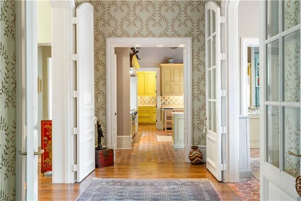a view of a hallway with wooden floor and a bathroom