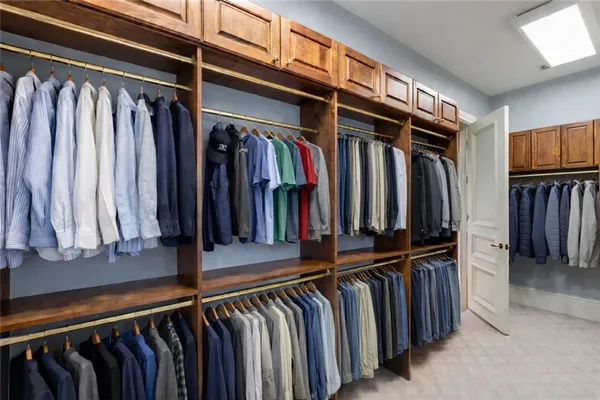 a view of walk in closet with clothes and shoes
