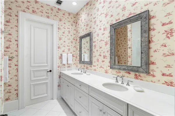 a bathroom with double vanity sink a mirror and a shower