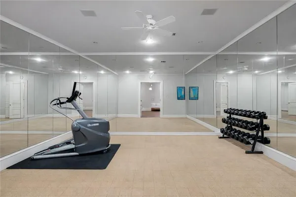a room with gym equipment and a chandelier