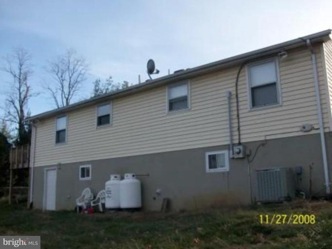 225 Granny Smith Road Linden, VA 22642 - Photo 2 of 13 a view of a white house with large windows and a table and chairs