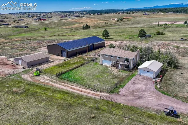 an aerial view of a house with a yard and lake view