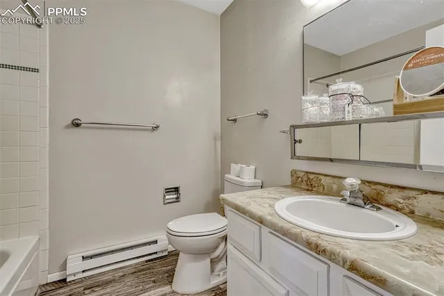 a bathroom with a granite countertop sink mirror vanity and toilet