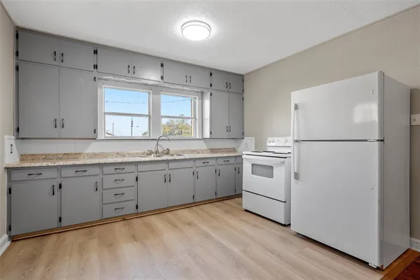 a kitchen with white cabinets and white appliances