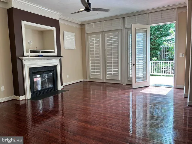 a view of a livingroom with wooden floor and a fireplace